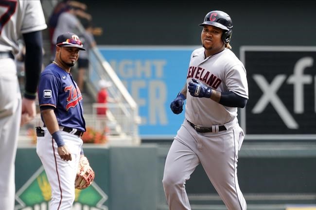 Cleveland Indians' Jose Ramirez, right, rounds the bases on a solo home run off Twins' Lewis Thorpe as third baseman Luis Arraez, left, watches in the first inning of a baseball game, Wednesday, Aug. 18, 2021, in Minneapolis. (AP Photo/Jim Mone)