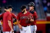 Arizona Diamondbacks starting pitcher Humberto Castellanos (54) smiles after being taken out of the baseball game by manager Torey Lovullo, left, as catcher Carson Kelly, right, waits during the sixth inning against the Philadelphia Phillies, Wednesday, Aug. 18, 2021, in Phoenix. (AP Photo/Ross D. Franklin)