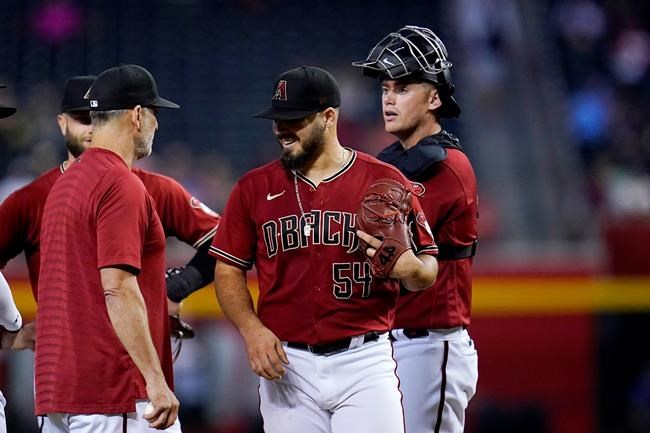 Arizona Diamondbacks starting pitcher Humberto Castellanos (54) smiles after being taken out of the baseball game by manager Torey Lovullo, left, as catcher Carson Kelly, right, waits during the sixth inning against the Philadelphia Phillies, Wednesday, Aug. 18, 2021, in Phoenix. (AP Photo/Ross D. Franklin)