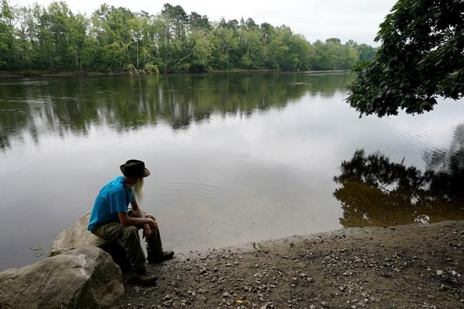 David Lidstone, 81, sits near the Merrimack River, Tuesday, Aug. 10, 2021, in Boscawen, N.H. Lidstone, an off-the-grid New Hampshire hermit known to locals as