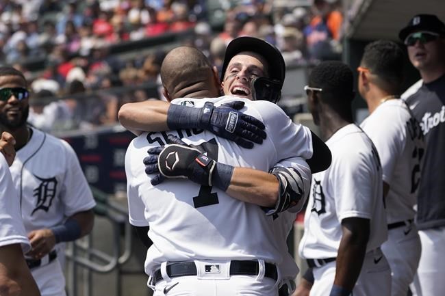Detroit Tigers' Zack Short hugs Jonathan Schoop (7) after hitting a solo home run against the Los Angeles Angels in the second inning of a baseball game in Detroit, Thursday, Aug. 19, 2021. (AP Photo/Paul Sancya)