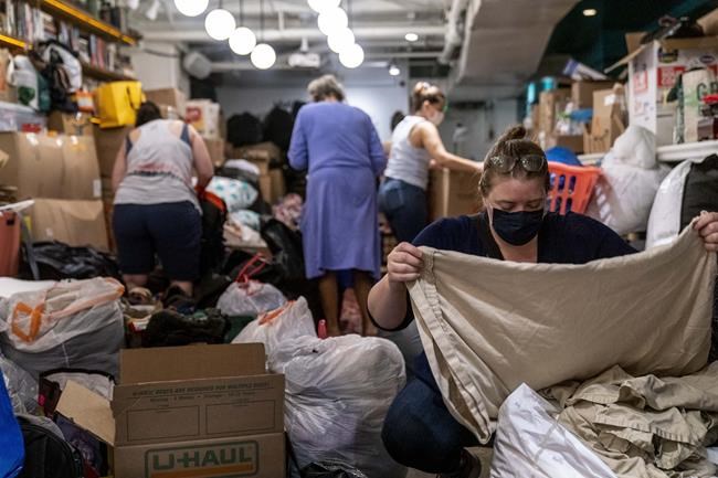 Annie Osborn, right, and other volunteers, receive, sort, and pack thousands of items donated to refugees resettling in the Washington region who are fleeing Afghanistan at Lapis, an Afghani restaurant in Adams Morgan neighborhood of Washington, Thursday, Aug. 19, 2021. The restaurant, owned by an Afghan family, will be accepting an assortment of household items including toiletries, linens, kitchen supplies and more at two restaurants, Lapis and The Berliner, each weekday until Aug. 27 to give to refugees resettling in the Washington region who are fleeing Afghanistan. (AP Photo/Andrew Harnik)