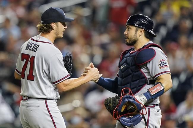 Atlanta Braves relief pitcher Jacob Webb, left, and catcher Travis d'Arnaud celebrate after a baseball game against the Washington Nationals at Nationals Park, Saturday, Aug. 14, 2021, in Washington. (AP Photo/Alex Brandon)