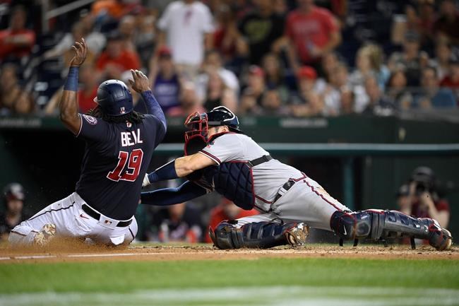 Washington Nationals' Josh Bell (19) is tagged out by Atlanta Braves catcher Travis d'Arnaud during the fourth inning of a baseball game Friday, Aug. 13, 2021, in Washington. (AP Photo/Nick Wass)