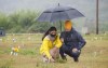 NDP Leader Jagmeet Singh and his wife Gurkiran Kaur Sidhu place flowers on a grave where 751 bodies were buried on the grounds of the Marieval Indian Residential School on Cowessess First Nation, Sask., Friday, Aug. 20, 2021. THE CANADIAN PRESS/Paul Chiasson