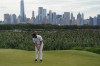 Jon Rahm, of Spain, sinks his putt on the 14th green as the Manhattan skyline looms in the distance in the second round at the Northern Trust golf tournament, Friday, Aug. 20, 2021, at Liberty National Golf Course in Jersey City, N.J. (AP Photo/John Minchillo)