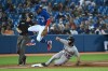 Detroit Tigers' Zack Short, 59, steals third base as Toronto Blue Jays' Santiago Espinal jumps clear in the eighth inning of an American League baseball game in Toronto on Friday, Aug. 20, 2021. THE CANADIAN PRESS/Jon Blacker