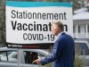 People's Party of Canada Leader Maxime Bernier walks by a sign advertising the region's main vaccination site at a hotel, after launching his campaign in Saint-Georges, Que., Friday, Aug. 20, 2021. Bernier will not be invited to participate in the federal election leaders' debates in Gatineau, Que., this September. THE CANADIAN PRESS/Jacques Boissinot