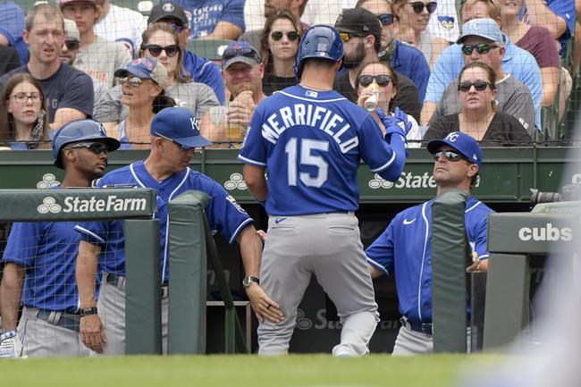 Kansas City Royals' Whit Merrifield (15) enters the dugout after scoring on wild pitch against the Chicago Cubs during the first inning of a baseball game Saturday, Aug. 21, 2021, in Chicago. (AP Photo/Mark Black)