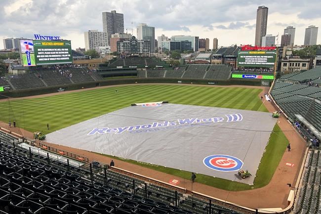 The Wrigley Field infield is covered with the rain tarp after the Chicago Cubs and Kansas City Royals head into a weather delay halfway through the seventh inning Saturday, Aug. 21, 2021, in Chicago. (AP Photo/Mark Black)