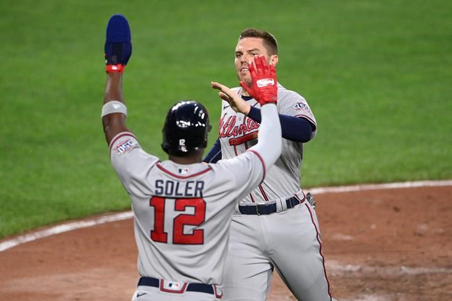 Atlanta Braves' Freddie Freeman, right, is greeted by Jorge Soler at home after they scored on a double by Dansby Swanson during the third inning of a baseball game against the Baltimore Orioles, Saturday, Aug. 21, 2021, in Baltimore. (AP Photo/Nick Wass)