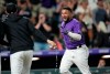 Teammates pursue Colorado Rockies' Elias Diaz, right, after his game-ending, three-run home run off Arizona Diamondbacks relief pitcher J.B. Wendelken during the ninth inning of a baseball game Saturday, Aug. 21, 2021, in Denver. The Rockies won 5-2. (AP Photo/David Zalubowski)