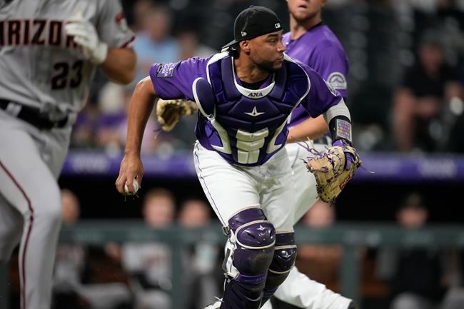 Colorado Rockies catcher Elias Diaz looks to throw after fielding a sacrifice bunt y Arizona Diamondbacks' Zac Gallen during the fifth inning of a baseball game Saturday, Aug. 21, 2021, in Denver. (AP Photo/David Zalubowski)