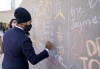 NDP leader Jagmeet Singh writes on a Jack Layton memorial wall to mark the tenth anniversary of the former NDP leader's death in Toronto , on Sunday, August 22, 2021. THE CANADIAN PRESS/Paul Chiasson