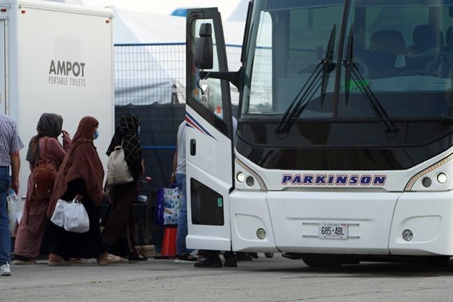 Refugees from Afghanistan and Canadian Citizens board a bus after being processed at Pearson Airport in Toronto, Tuesday, Aug 17, 2021, after arriving indirectly from Afghanistan. Defence Minister Harjit Sajjan says Canada will work tirelessly to evacuate people from strife-ridden Afghanistan