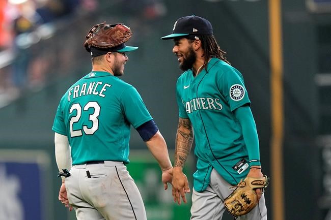 Seattle Mariners' Ty France (23) and J.P. Crawford celebrate after a baseball game against the Houston Astros Sunday, Aug. 22, 2021, in Houston. The Mariners won 6-3 in 11 innings. (AP Photo/David J. Phillip)