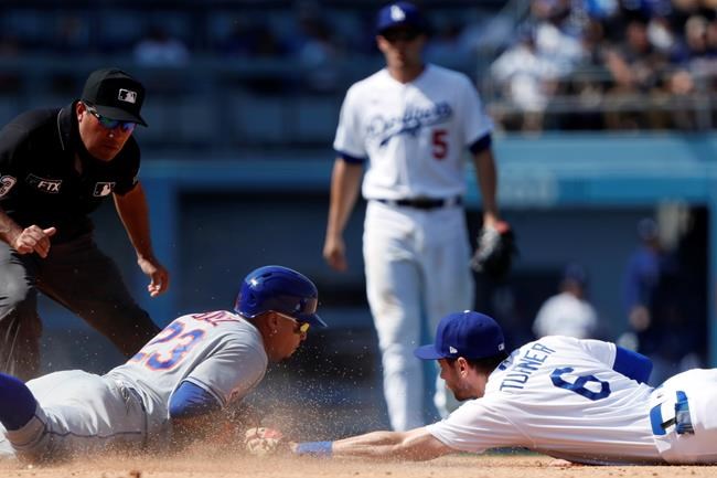 New York Mets' Javier Baez, bottom left, eludes a tag by Los Angeles Dodgers second baseman Trea Turner, bottom right, for a double during the seventh inning of a baseball game in Los Angeles, Sunday, Aug. 22, 2021. (AP Photo/Alex Gallardo)
