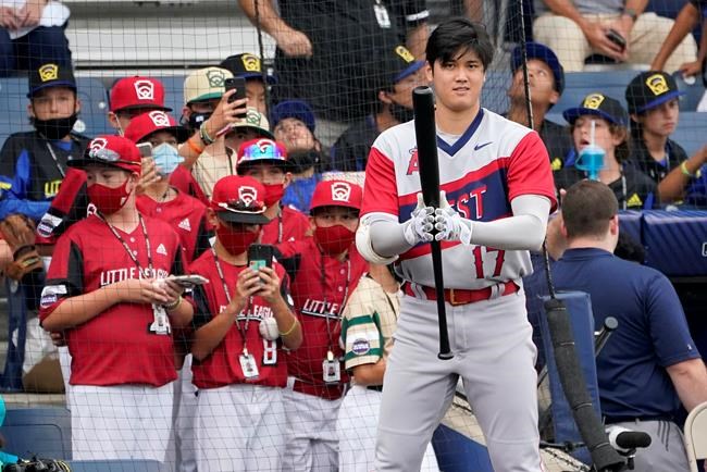 Los Angeles Angels' Shohei Ohtani warms up as Little Leaguers from Hamilton, Ohio, in red, watch before the Little League Classic baseball game against the Cleveland Indians at Bowman Stadium in Williamsport, Pa., Sunday, Aug. 22, 2021. (AP Photo/Tom E. Puskar)