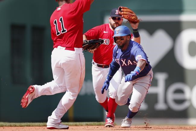 Texas Rangers' Yonny Hernandez, right, is caught in a run down at second base between Boston Red Sox's Rafael Devers (11) and Kyle Schwarber during the fifth inning of a baseball game, Monday, Aug. 23, 2021, in Boston. (AP Photo/Michael Dwyer)