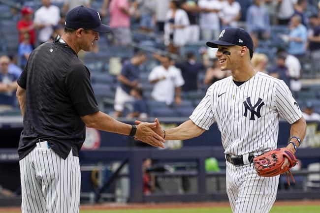 New York Yankees' Andrew Velazquez, right, celebrates with manager Aaron Boone after the Yankees defeated the Minnesota Twins in a baseball game, Saturday, Aug. 21, 2021, in New York. The Yankees won 7-1. (AP Photo/Mary Altaffer)