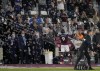 West Ham's Michail Antonio holds aloft a cardboard cutout of himself as he celebrates after scoring his side's third goal during the English Premier League soccer match between West Ham United and Leicester City and at the London Stadium in London, Monday, Aug. 23, 2021. (AP Photo/Alastair Grant)