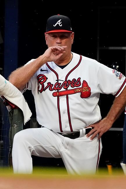 Atlanta Braves manager Brian Snitker watches from the dugout during the team's baseball game against the Cincinnati Reds on Wednesday, Aug. 11, 2021, in Atlanta. (AP Photo/John Bazemore)
