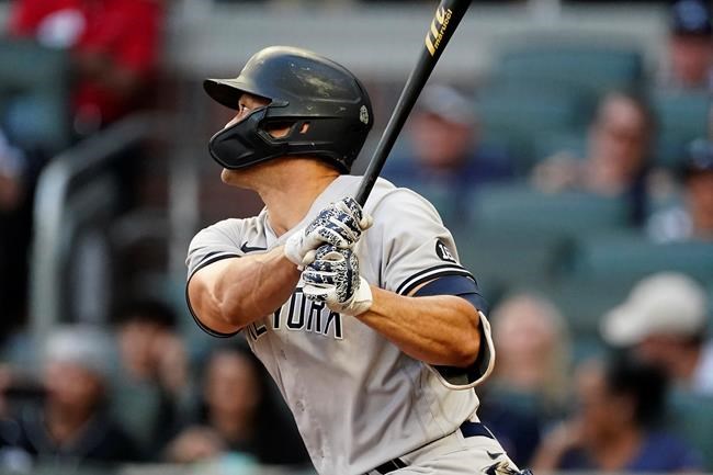 New York Yankees' Giancarlo Stanton follows though on a solo home run in the second during a baseball game against the Atlanta Braves, Monday, Aug. 23, 2021, in Atlanta. (AP Photo/John Bazemore)