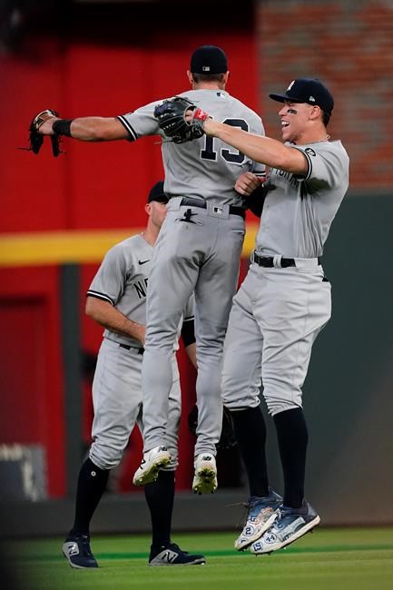 New York Yankees outfielders Aaron Judge (99), right, and Joey Gallo (13) celebrate after defeating the Atlanta Braves in a baseball game Monday, Aug. 23, 2021, in Atlanta. (AP Photo/John Bazemore)