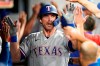 Texas Rangers' DJ Peters is congratulated by teammates after hitting a three-run home run in the ninth inning of a baseball game against the Cleveland Indians, Tuesday, Aug. 24, 2021, in Cleveland. The Rangers won 7-3. (AP Photo/Tony Dejak)