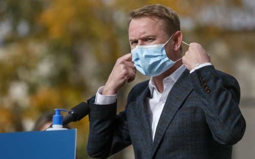 Minister of Health Tyler Shandro, removes his made-in-Calgary mask while announcing a new agreement between Alberta Health Services and a local manufacturer to produce medical equipment, in Calgary on Oct. 7, 2020. THE CANADIAN PRESS/Jeff McIntosh