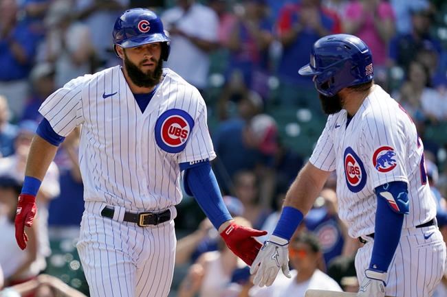 Chicago Cubs' David Bote, left, celebrates with Austin Romine after hitting a solo home run in the second inning in the first baseball game of a doubleheader against the Colorado Rockies in Chicago, Wednesday, Aug. 25, 2021. (AP Photo/Nam Y. Huh)