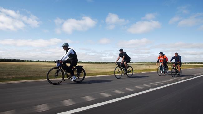 Rylee Nepinak, left, who is cycling across Canada, rides with supporters near Winnipeg on Wednesday, Aug. 25, 2021. Nepinak is riding to raise awareness of a suicide crisis among members of the Tataskweyak Cree Nation in July and of teen suicide on reserves. THE CANADIAN PRESS/John Woods