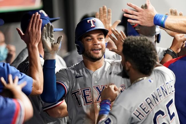 Texas Rangers' Jason Martin is congratulated by teammates after his two-run home run during the sixth inning of the team's baseball game against the Cleveland Indians, Wednesday, Aug. 25, 2021, in Cleveland. (AP Photo/Tony Dejak)