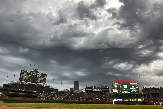 Storm clouds descend over Wrigley Field bringing a steady light rain in the fourth inning of the second game of a baseball doubleheader between the Chicago Cubs and the Colorado Rockies Wednesday, Aug. 25, 2021, in Chicago. (AP Photo/Charles Rex Arbogast)