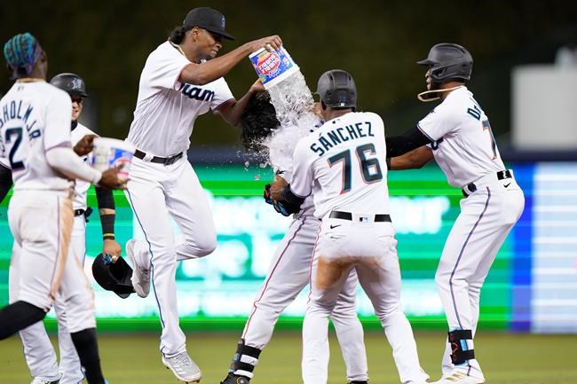 Miami Marlins' Edward Cabrera douses Jorge Alfaro after Alfaro drove in the winning run to give the team a 4-3 win in 10 innings over the Washington Nationals in a baseball game Wednesday, Aug. 25, 2021, in Miami. (AP Photo/Wilfredo Lee)