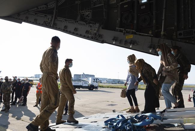 This photo provided by the French Army Thursday, Aug.26, 2021 shows Afghan refugees arriving in a military plane at Roissy airport, north of Paris, Wednesday, Aug.25, 2021. At least 1720 Afghans and a hundred French people have been evacuated by France since the beginning of the operation last week. French President Emmanuel Macron promised France would evacuate Afghans who worked for the country as well as activists and others under threat. (Eric Cadiou/Etat Major des Armees via AP)