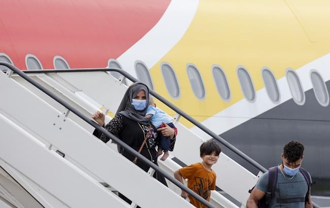 People disembark from a Belgian chartered plane, as part of an evacuation from Afghanistan, upon arrival at Melsbroek Military Airport in Melsbroek, Belgium, Thursday, Aug. 26, 2021. (AP Photo/Olivier Matthys)