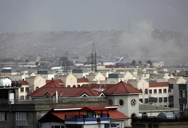 Smoke rises from a deadly explosion outside the airport in Kabul, Afghanistan, Thursday, Aug. 26, 2021. Two suicide bombers and gunmen have targeted crowds massing near the Kabul airport, in the waning days of a massive airlift that has drawn thousands of people seeking to flee the Taliban takeover of Afghanistan. (AP Photo/Wali Sabawoon)