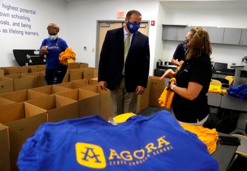 Dr. Richard Jensen, CEO at Agora Cyber Charter School, center, talks with Chris Moser, lead family coach in the northeast US, as she and other staff fill boxes with Agora supplies for family coaches to distribute to students, Wednesday, Aug. 4, 2021, in King of Prussia, Pa. (AP Photo/Jacqueline Larma)