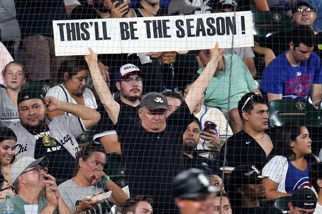 A spectator holds a sign during the fifth inning of the team's baseball game against the Chicago Cubs on Friday, Aug. 27, 2021, in Chicago. (AP Photo/Nam Y. Huh)