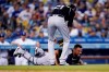 Colorado Rockies catcher Elias Diaz, bottom, grimaces next to starting pitcher Kyle Freeland (21) after Diaz collided with first baseman C.J. Cron on a pop fly by Los Angeles Dodgers' Justin Turner, who was out during the third inning of a baseball game Friday, Aug. 27, 2021, in Los Angeles. (AP Photo/Marcio Jose Sanchez)