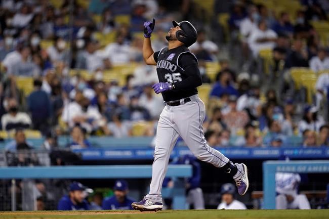 Colorado Rockies' Elias Diaz points skyward as he reaches home plate on a solo home run against the Los Angeles Dodgers during the ninth inning of a baseball game Friday, Aug. 27, 2021, in Los Angeles. (AP Photo/Marcio Jose Sanchez)