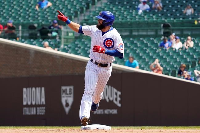 Chicago Cubs' David Bote points as he rounds the bases after hitting a solo home run in the second inning in the first baseball game of a doubleheader against the Colorado Rockies in Chicago, Wednesday, Aug. 25, 2021. (AP Photo/Nam Y. Huh)