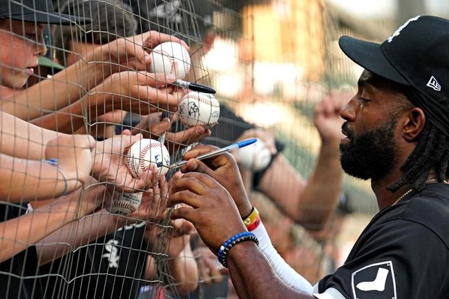 Chicago White Sox left fielder Brian Goodwin gives autographs to fans before a baseball game against the Chicago Cubs in Chicago, Saturday, Aug. 28, 2021. (AP Photo/Nam Y. Huh)