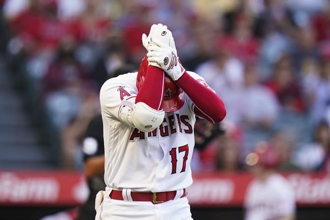 Los Angeles Angels' Shohei Ohtani, of Japan, holds his wrist after he struck out during the first inning of the team's baseball game against the San Diego Padres in Anaheim, Calif., Saturday, Aug. 28, 2021. (AP Photo/Jae C. Hong)