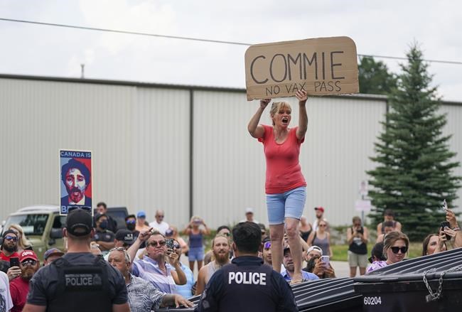 Protesters scream as police secure the property as Liberal leader Justin Trudeau announces green incentives towards climate change at a campaign stop during the Canadian federal election campaign in Cambridge, Ont., on Sunday, August 29, 2021. THE CANADIAN PRESS/Nathan Denette