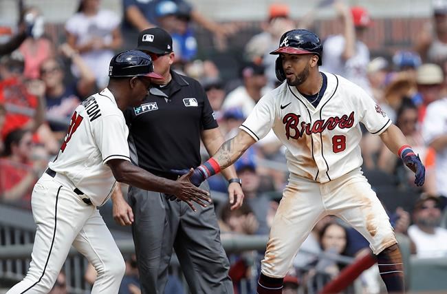 Atlanta Braves' Eddie Rosario (8) celebrates with third base coach Ron Washington, left, after hitting a two-run triple against the San Francisco Giants in the sixth inning of a baseball game Sunday, Aug. 29, 2021, in Atlanta. (AP Photo/Ben Margot)