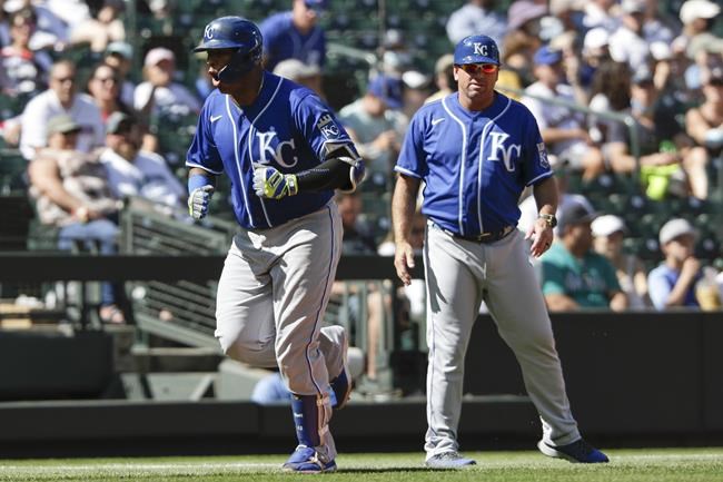 Kansas City Royals' Salvador Perez, left, heads home as third base coach Vance Wilson looks on after Perez's home run during the sixth inning of a baseball game against the Seattle Mariners, Sunday, Aug. 29, 2021, in Seattle. (AP Photo/Jason Redmond)
