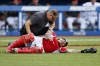 A trainer, top, checks on Cleveland Indians' Wilson Ramos who was injured during the seventh inning of a baseball game against the Boston Red Sox, Sunday, Aug. 29, 2021, in Cleveland. (AP Photo/Ron Schwane)