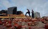 New Orleans Firefighters assess damage as they look through debris after a building collapsed from the effects of Hurricane Ida, Monday, Aug. 30, 2021, in New Orleans, La. All of New Orleans lost power right around sunset Sunday as the hurricane blew ashore on the 16th anniversary of Katrina, leading to an uneasy night of pouring rain and howling wind. The weather died down shortly before dawn. (AP Photo/Eric Gay)
